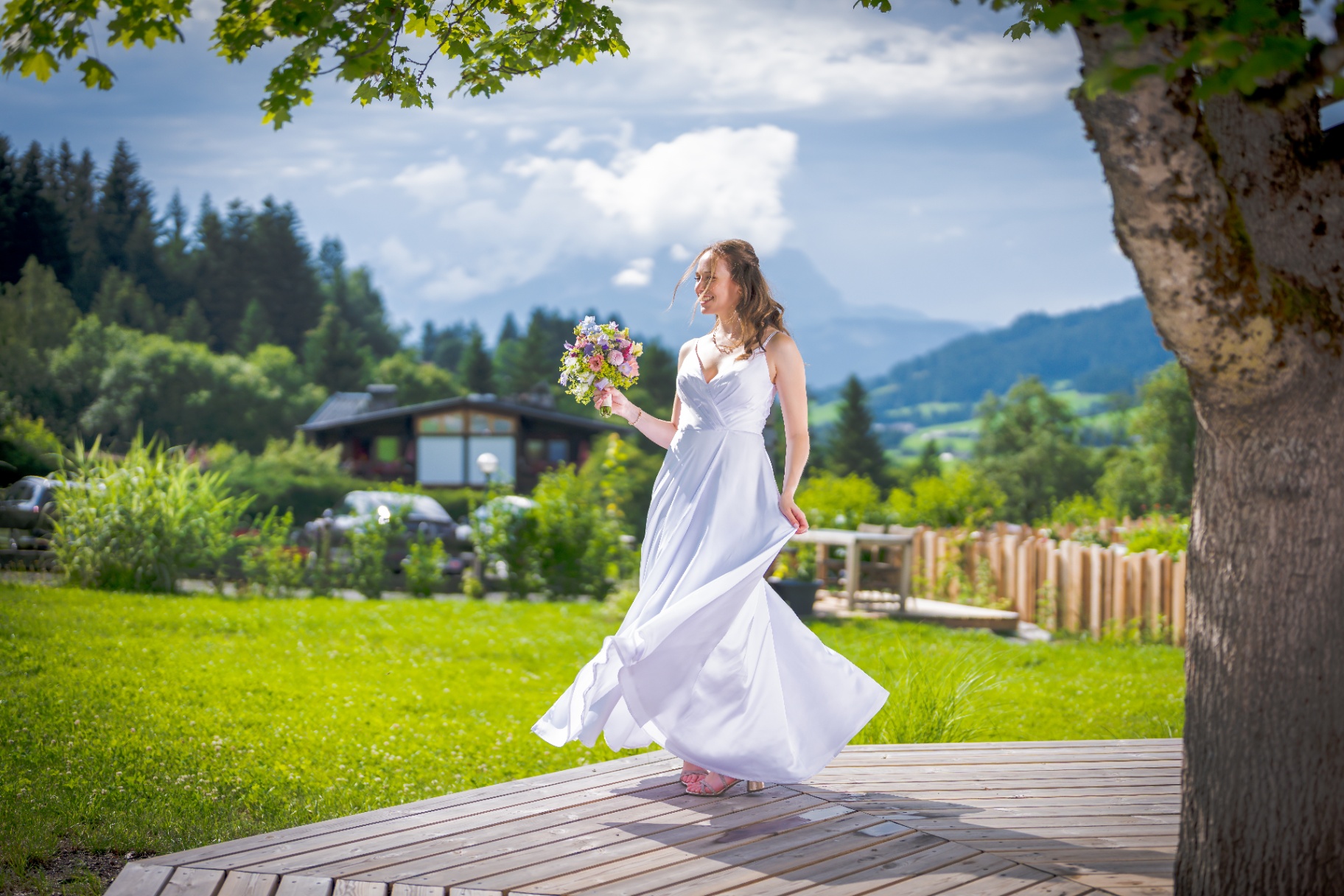 Braut Anna-Lena tanzt im Wind vor Bergpanorama